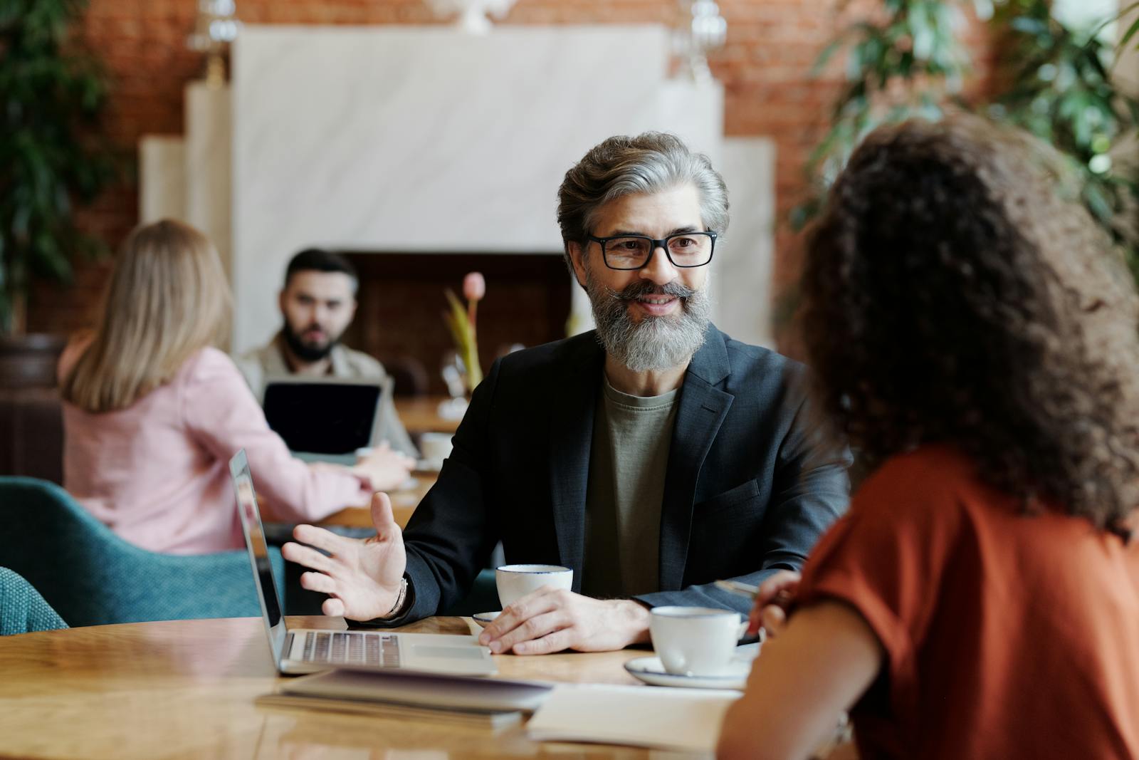 A Bearded Man in Coffee Shop Talking to a Woman