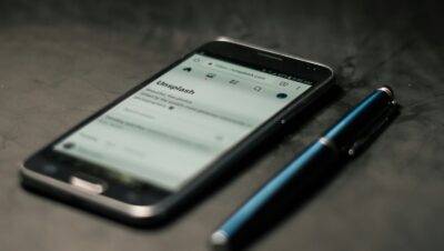black smartphone beside pen